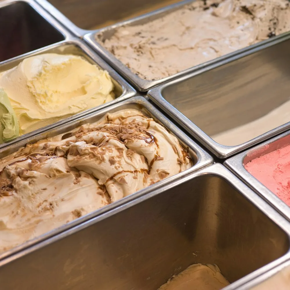Tubs of freshly churned ice cream in a scoop shop counter