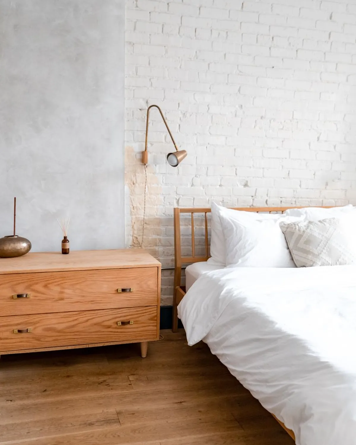 Arc bed frame made up against a pale wall