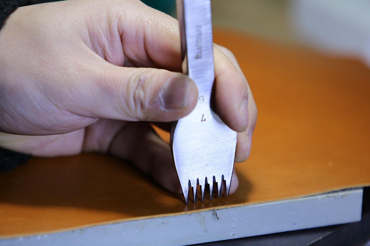A pricking iron marking stitch holes in leather